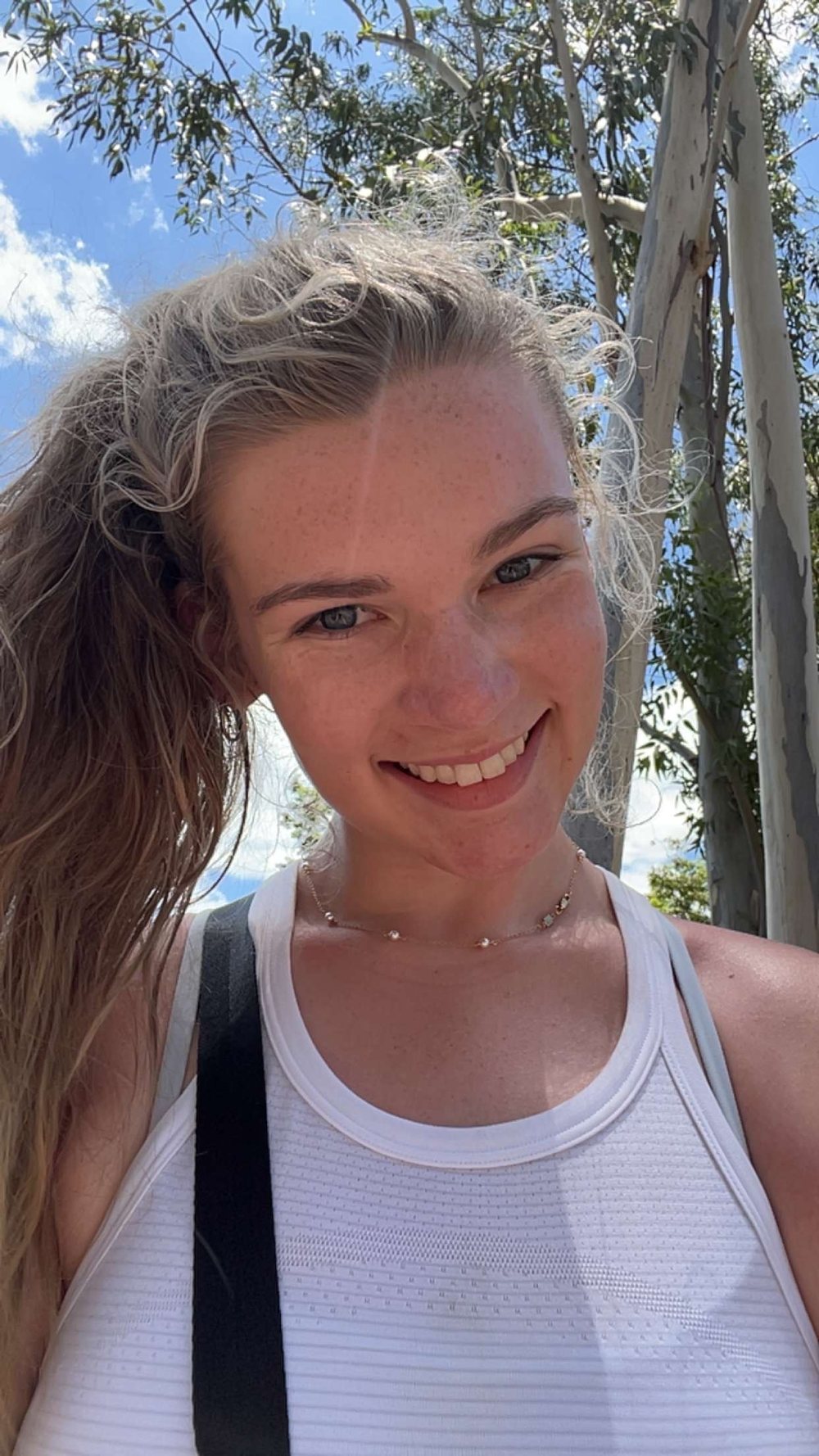 Avery smiling outdoors on a sunny day